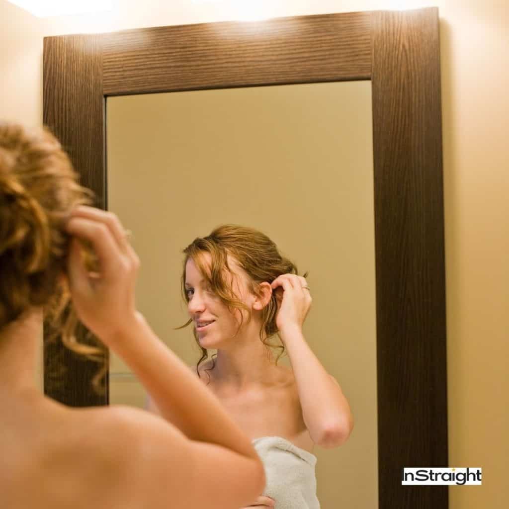 lady in front of a bathroom mirror